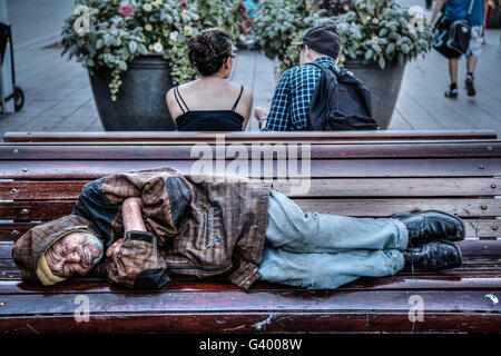 Montreal, Canada - 20 AGO 2012: un senzatetto uomo dorme su una panchina nel parco in Montreal, QC, Canada. Foto Stock