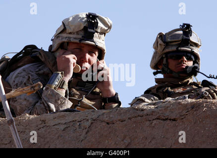 Stati Uniti Marine dà indicazioni alle unità su due diverse radio da un tetto in Afghanistan. Foto Stock