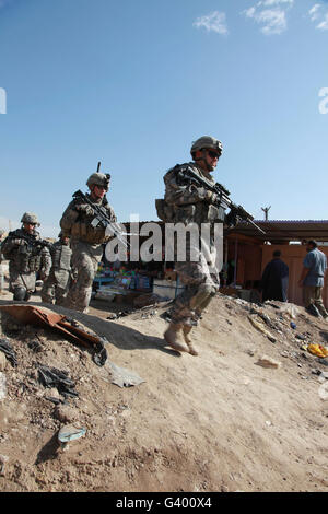 Stati Uniti I soldati dell esercito a piedi attraverso un mercato in Ebnkathwer, Iraq. Foto Stock