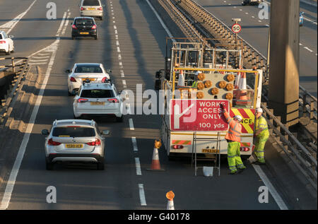 I lavoratori di erigere il traffico stradale segno sulla autostrada urbana,Glasgow, Scotland, Regno Unito, Foto Stock