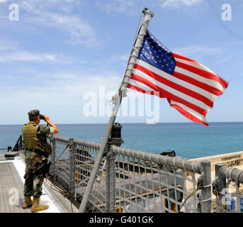 Stati Uniti Navy Seaman sorge guarda sul ponte in elicottero a bordo ad alta velocità a nave Swift. Foto Stock