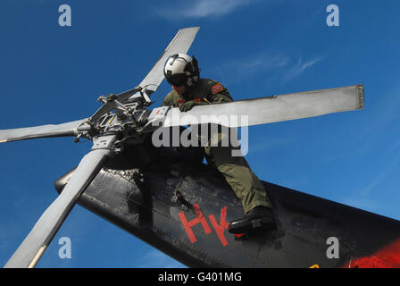 Un soldato esegue una ispezione pre-volo su una SH-60B Mare Hawk elicottero rotore di coda. Foto Stock