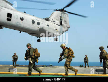 Stati Uniti Marines corrono attraverso il ponte dopo fast roping da un CH-46E Sea Knight. Foto Stock