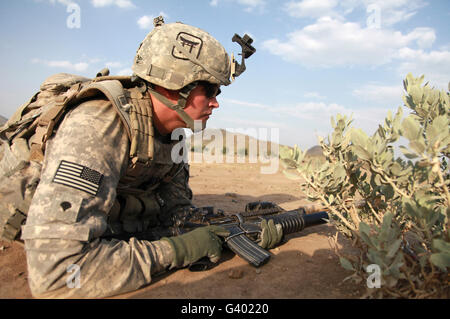 U.S Army Specialist fornisce la sicurezza mentre di pattuglia in Afghanistan. Foto Stock