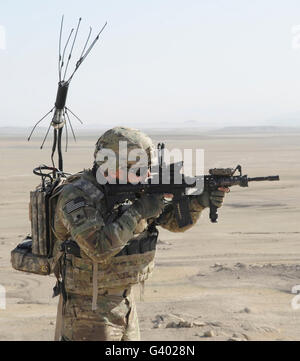 Stati Uniti Specialista dell'esercito scansiona la sua area durante una visita alla Diga Dahla. Foto Stock