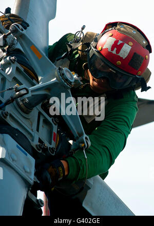 Mechanic ispeziona un MH-60R Sea Hawk elicottero. Foto Stock