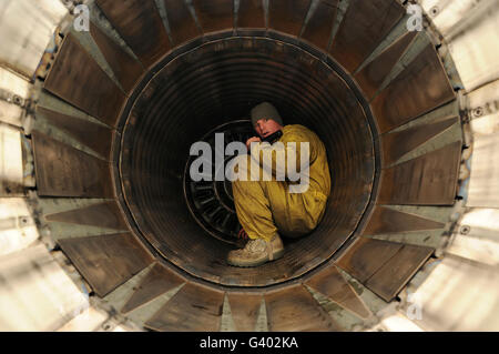 Un tecnico di aeromobili ispeziona il gas di scarico di un F-16 Fighting Falcon. Foto Stock