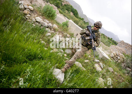 Stati Uniti Specialista dell'esercito passeggiate attraverso un campo in Afghanistan. Foto Stock