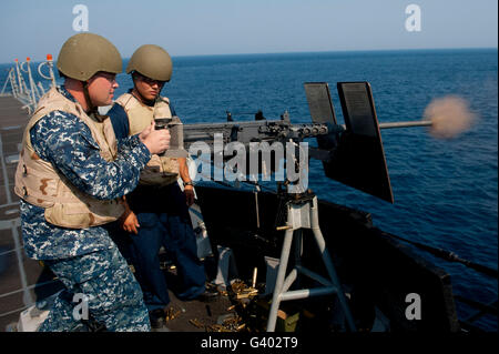 Sonar incendi tecnico un .50 cal machine gun a bordo della USS Jason Dunham. Foto Stock