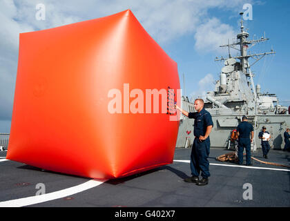 I marinai preparare per distribuire un killer di pomodoro per un esercizio gunnery a bordo della USS Decatur. Foto Stock