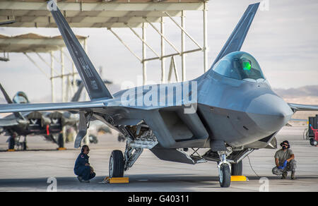 Manutentori di aeromobili condotta pre-volo checkson un F-22 Raptor. Foto Stock