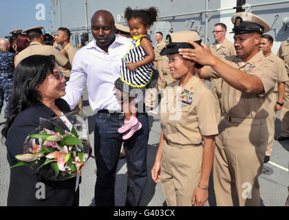 I membri della famiglia si riuniscono intorno al chief petty officer ashe riceve la sua combinazione di copertura. Foto Stock