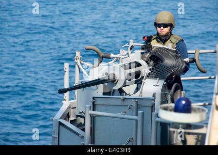 Da bombardieri Mate mans il Mark 38 mitragliatrice a bordo della USS Iwo Jima. Foto Stock