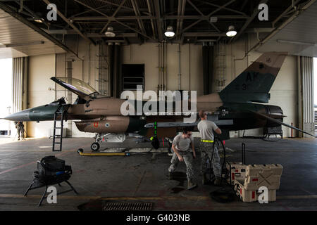 Avieri riparare i sistemi di armamenti su di un F-16C Fighting Falcon. Foto Stock