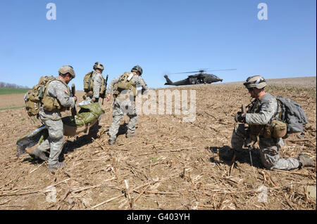 Berretti Verdi spostare la simulazione di una vittima di un UH-60 elicottero per il trasporto. Foto Stock