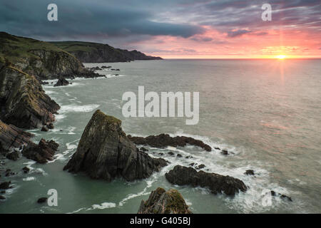 Sunrise drammatico paesaggio oltre il punto di Bull nel Devon England Foto Stock