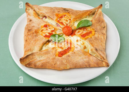 Pizza italiana calzone con mozzarella e prosciutto e pomodoro Foto Stock