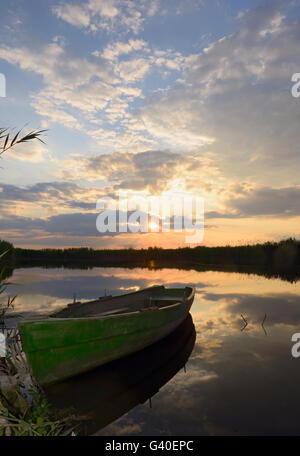 Barca dei pescatori al tramonto in estate Foto Stock