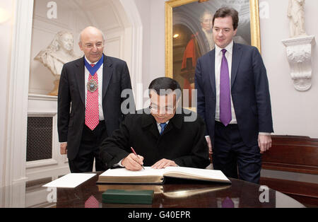 Il vice Premier cinese li Keqiang (centro) firma il libro dei visitatori guardato dal sindaco di Londra Michael Bear (a sinistra) e dal Cancelliere dello scacchiere George Osborne (a destra) prima di un incontro alla Mansion House nel centro di Londra. Foto Stock