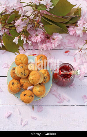 Deliziosa scozzese, muffin su una rosa di legno tabella, fresca prima colazione in giardino di primavera Foto Stock