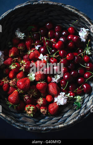 Le ciliegie e fragole in un cestello Foto Stock