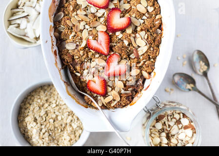 Una grande ciotola ovale di fragole e rabarbaro Colazione croccanti di avena è fotografato dall'alto. Foto Stock