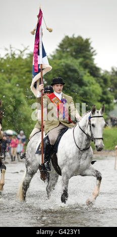 Selkirk, Scotland, Regno Unito. 17 giu 2016. Alfiere 28 enne Rory monaci conduce la cavaclade attraverso la Ettrick. Selkirk Equitazione comune si svolge il secondo venerdì dopo il primo lunedì di giugno Selkirk Equitazione comune commemora come, dopo la disastrosa Battaglia di Flodden nel 1513 da ottanta uomini che ha lasciato la città, uno solo - Fletcher - cuscinetto restituito a catturato bandiera inglese. La leggenda narra che ha gettato la bandiera sulla sua testa per indicare che tutti gli altri uomini di Selkirk era stato abbattuto. Credito: Jim Gibson/Alamy Live News Foto Stock