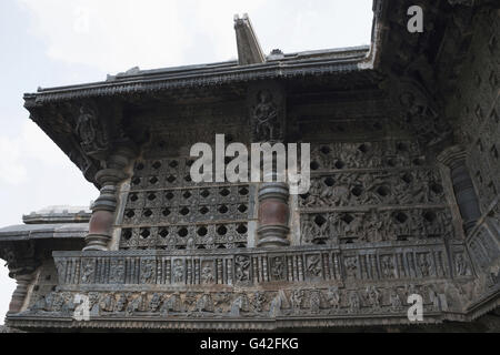 Ornati finestra traforata e Madanikas (celesti damigelle) sulla sommità dei pilastri. Tempio di Chennakeshava, Belur, Karnataka, India Foto Stock