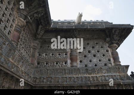 Ornati finestra traforata e Madanikas (celesti damigelle) sulla sommità dei pilastri. Tempio di Chennakeshava, Belur, Karnataka, India Foto Stock