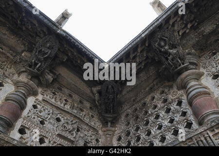 Ornati finestra traforata e Madanikas (celesti damigelle) sulla sommità dei pilastri. Tempio di Chennakeshava, Belur, Karnataka, India Foto Stock