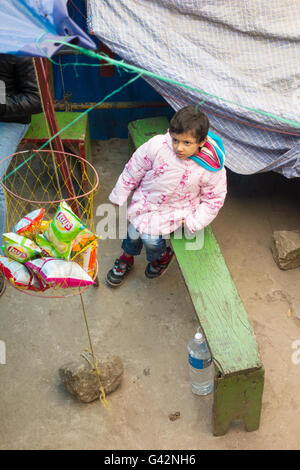 Grazioso piccolo ragazza indiana bambino guardando il Lay's potato chips pacchetti in Darjeeling, West Bengal, India Foto Stock