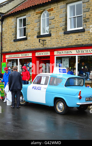 Il villaggio di goathland shop in North Yorkshire Moors con una Ford anglia auto della polizia. impostazione ofictional villaggio di aidensfield Foto Stock