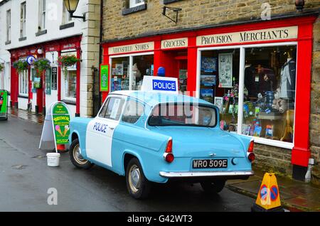 Il villaggio di goathland shop in North Yorkshire Moors con una Ford anglia auto della polizia. impostazione ofictional villaggio di aidensfield Foto Stock