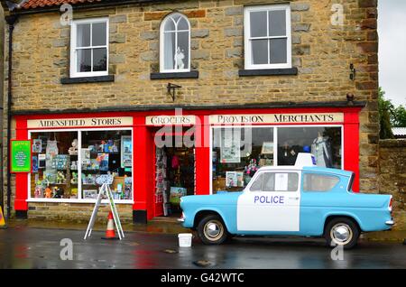 Il villaggio di goathland shop in North Yorkshire Moors con una Ford anglia auto della polizia. impostazione ofictional villaggio di aidensfield Foto Stock