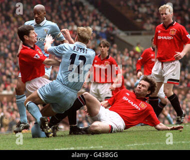 Una ferita orribile per Dave Busst di Coventry City (no 12) durante un'azione con Denis Irwin (a sinistra) e Brian McClair di Manchester United a Old Trafford. Busst è stato teso dal campo con una gamba gravemente rotta. Foto Stock