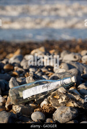 Un messaggio in bottiglia su una spiaggia ghiaiosa Foto Stock