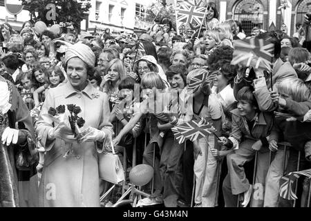 La regina Elisabetta II riceve fiori durante una passeggiata tra le folle di Ipswich, durante il suo Silver Jubilee Tour of Britain. Foto Stock