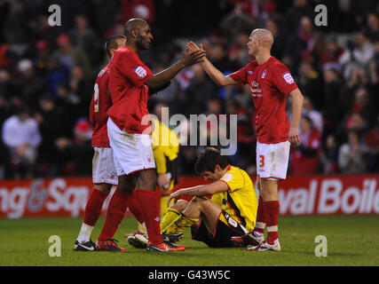 Il DELE Adebola di Nottingham Forest (a sinistra) e Paul Konchesky celebrano la vittoria dopo il fischio finale, mentre il Danny Graham di Watford si siede sul pavimento durante la partita del campionato Npower al City Ground di Nottingham. Foto Stock