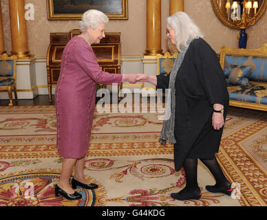 La Regina Elisabetta II della Gran Bretagna presenta il poeta Gillian Clarke con la sua medaglia d'oro per la poesia a Buckingham Palace. Foto Stock