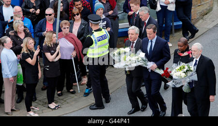 Ombra Segretario degli esteri Hilary Benn cammina dietro Commons Speaker John Bercow (quarta a destra), il Primo Ministro David Cameron (terza a destra), altoparlante cappellano del Reverendo Rose Hudson-Wilkin (seconda a destra) e leader del partito laburista Jeremy Corbyn (destra) come essi arrivano a porre fiori in Birstall, West Yorkshire, dopo il lavoro MP Jo Cox è stato girato e pugnalato a morte in strada al di fuori del suo collegio consigli chirurgia. Foto Stock