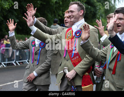 Royal Alfiere Rory J. Monaci (centro) onde ai piloti che partecipano al Selkirk Equitazione comune, una secolare tradizione nel royal burgh di Selkirk Scottish Borders. Foto Stock