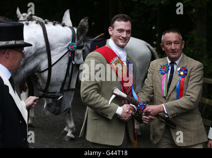 Royal Alfiere Rory J. Monaci (centro) è dato un dono durante il Selkirk Equitazione comune, una secolare tradizione nel royal burgh di Selkirk Scottish Borders. Foto Stock