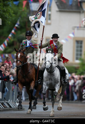 Royal Alfiere Rory J. Monaci (destra) conduce i piloti che prendono parte alla Selkirk Equitazione comune, una secolare tradizione nel royal burgh di Selkirk Scottish Borders. Foto Stock