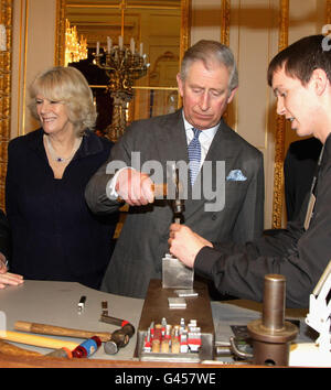 Il Principe del Galles trasforma un segno distintivo in un pezzo d'argento mentre lui e la Duchessa di Cornovaglia visitano la Goldsmiths Hall di Londra. Foto Stock