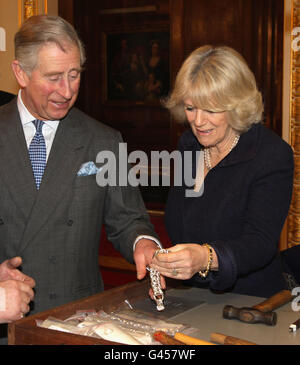 Il Principe di Galles e la Duchessa di Cornovaglia guardano i gioielli durante una visita alla Goldsmiths Hall di Londra. Foto Stock