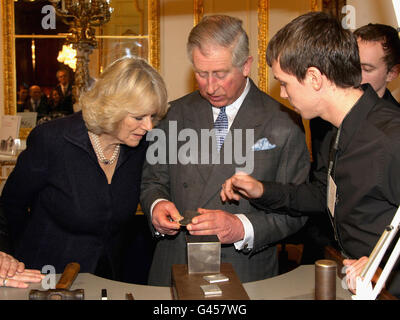 Il Principe di Galles esamina il suo lavoro dopo che ha segnato un pezzo d'argento durante una visita con la Duchessa di Cornovaglia a Goldsmiths Hall, Londra. Foto Stock