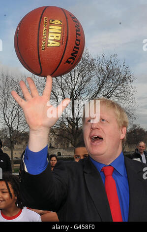 Il sindaco di Londra Boris Johnson bilancia un basket a una fotocellula per lanciare la settimana della pallacanestro NBA al Potters Fields Park, Londra. Foto Stock