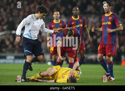 Andres Iniesta (centro) di Barcellona affronta Jack Wilshere (piano) dell'Arsenal Una sfida come arbitro massimo Busacca (a sinistra) guarda sopra Foto Stock