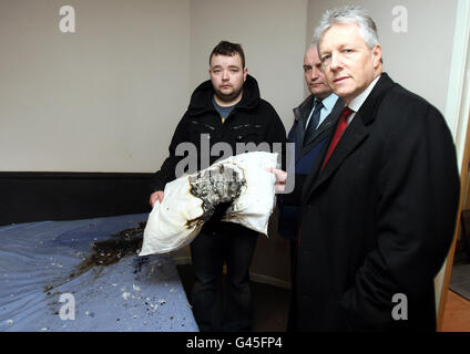 Primo Ministro e leader del DUP, Peter Robinson (destra), con John Smyth (sinistra) e Trevor Clarke, MLA, nella camera da letto dove esplose una bomba a tubo. Foto Stock