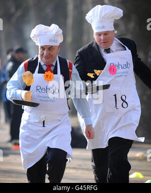 Il deputato del lavoro Stephen Pound (a sinistra) e lo Sky Political Editor Adam Boulton competono nella Rehab UK Parliament Pancake Race a Westminster, Londra, per contribuire ad aumentare la consapevolezza della carità - che aiuta le persone con disabilità. Foto Stock